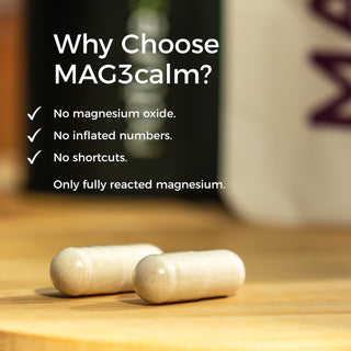 Two capsules on a wooden surface with text highlighting the benefits of MAG3calm blend.